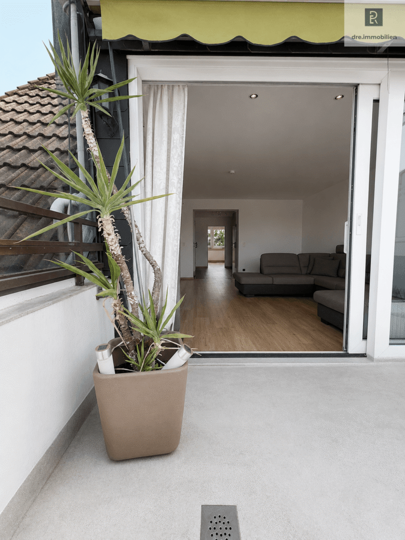 Blick vom Balkon ins Wohnzimmer (Dieses Bild wurde mithilfe künstlicher Intelligenz bearbeitet. Einzelne dargestellte Elemente entsprechen möglicherweise nicht dem tatsächlichen Zustand)