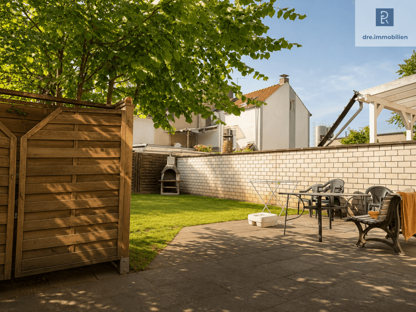 Sonnige Terrasse mit Gartenbereich (mit KI bearbeitet)